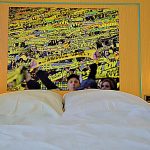 Innenansicht: großes Hotelzimmer, breites Bett, Riesenbild von BVB Fankurve über Bett