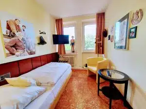 Kleines Einzelzimmer mit Bett, Sessel Tisch, TV mit Bonanza Bildern und Gegenständen Lünen Hotel am Lippepark