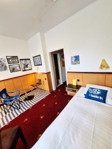 Schalke Themen -Budget Zimmer Retro-Art Hotel Lünen mit signiertem Neuer Trikot aus seiner Schalker Zeit, Wimpel signiert, Kissen, Bilder, Bett, Sessel im Retro Art Hotel Lünen