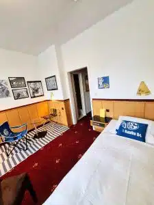 Schalke Themen -Budget Zimmer Retro-Art Hotel Lünen mit signiertem Trikot aus seiner Schalker Zeit, Wimpel signiert, Kissen, Bilder, Bett, Sessel im Retro Art Hotel Lünen