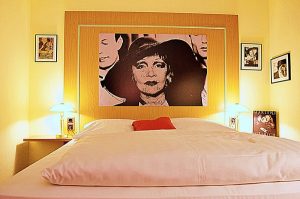Hotel Lünen mit Themenzimmer iMarlene Dietrich mit großem Portrait über dem Bett