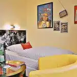 Einzelzimmer mit Boxspringbett und Heinz Erhardt Dekoration im Retro Hotel Lünen