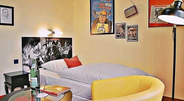 Einzelzimmer mit Boxspringbett und Heinz Erhardt Dekoration im Retro Hotel Lünen