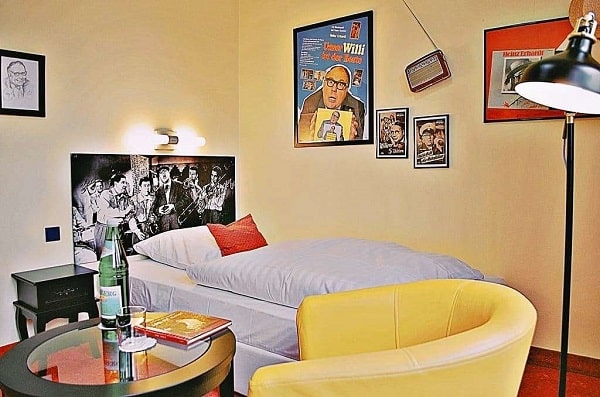 Einzelzimmer mit Boxspringbett und Heinz Erhardt Dekoration im Retro Hotel Lünen